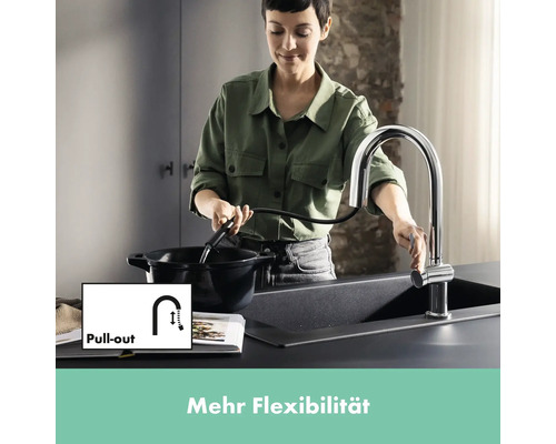 Frau befüllt Topf mit ausziehbarer Küchenarmatur am Spültisch