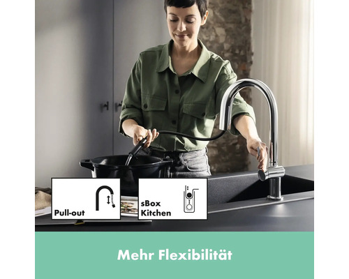 Frau benutzt Spültischarmatur mit Ausziehbrause in Küche