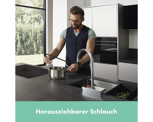 Mann befüllt Topf mit ausziehbarer Küchenarmatur