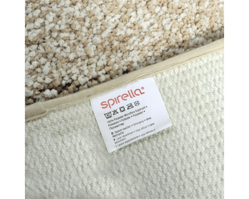 Etikett mit Pflegehinweisen für einen Teppich: Waschbar bis 40 Grad, nicht bleichen, nicht bügeln, kann chemisch gereinigt werden, nicht im Trockner trocknen, Material 100 Prozent Polyester Microfaser Supersoft