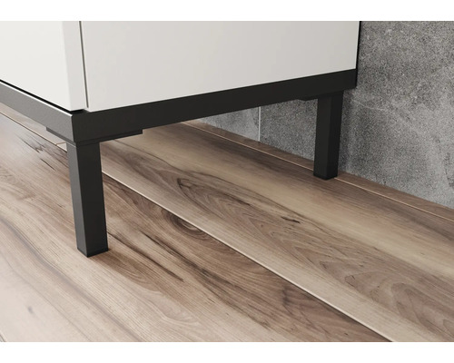 Detailaufnahme eines weißen Waschtischunterschranks mit schwarzen Metallfüßen auf einem Holzboden