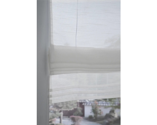 Nahaufnahme eines weißen Faltstores am Fenster für Sichtschutz und Dekoration.
