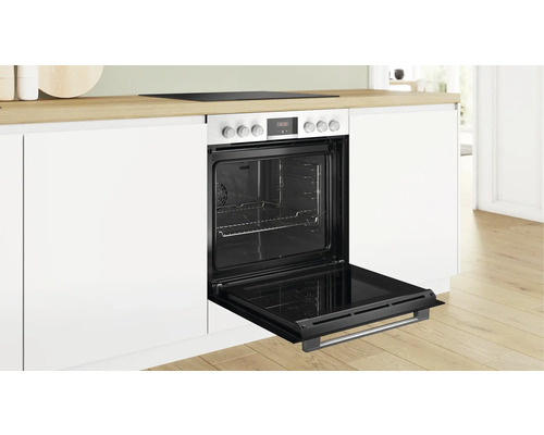 Einbauherd mit geöffneter Ofentür in einer hellen Küche.