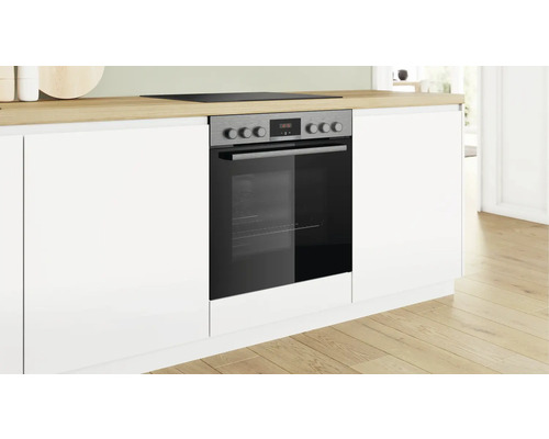 Einbauherd in einer modernen Küche mit weißen Schränken und einer hellen Holzarbeitsplatte