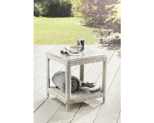 Gartentisch aus Polyrattan mit Glasplatte, Ablagefach und Dekoration im Garten