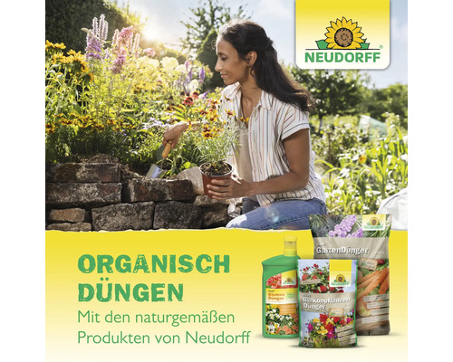 Frau pflanzt Blumen mit Neudorff Gartendünger Produkten in einen Garten.
