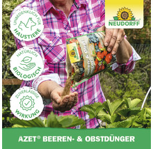 Eine Person düngt Beeren und Obst mit Azet Beeren- und Obstdünger von Neudorff. Das Produkt ist unbedenklich für Haustiere, natürlich und biologisch, und bietet eine zuverlässige Wirkung. Neudorff Logo.