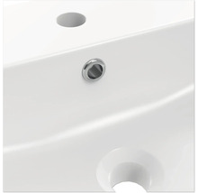 Detailansicht eines weißen Waschbeckens mit Hahnloch und Überlauf