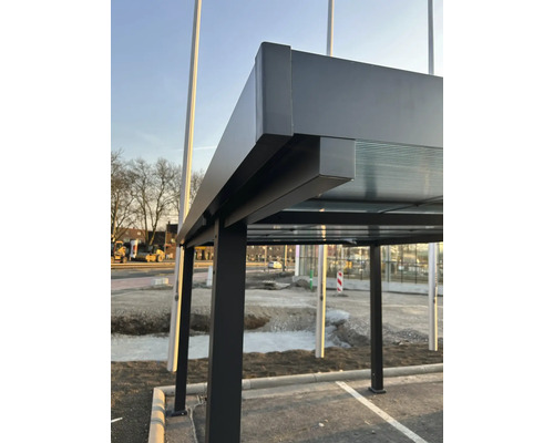 Detailansicht einer Bushaltestelle mit Metallstruktur und Glasdach