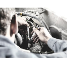 Mechaniker mit Schraubenschlüsseln bei der Reparatur eines Motors