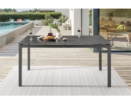 Grauer rechteckiger Gartentisch mit Gedeck im Außenbereich