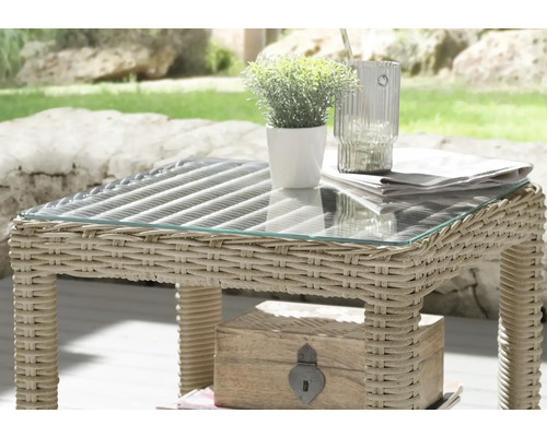 Gartentisch mit Glasplatte und Rattanstruktur mit Dekorationen