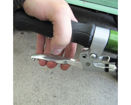 Eine Hand betätigt einen silberfarbenen Fahrradbremshebel mit schwarzem Griff