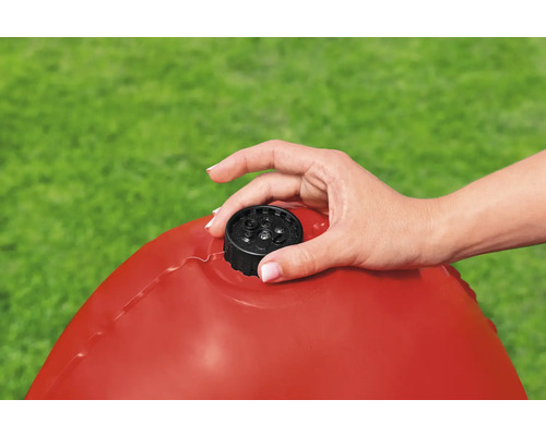 Eine Hand schraubt den Verschluss auf einen roten Schwimmreifen