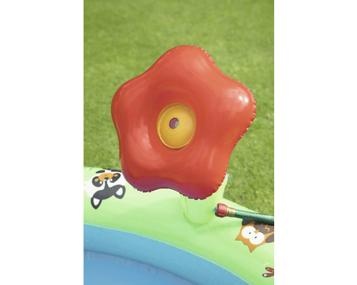 Aufblasbares Planschbecken mit rotem Sprinkleraufsatz im Garten.