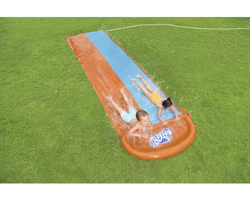 Aufblasbare Wasserrutsche mit Kindern im Garten.