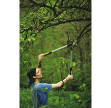 Frau schneidet Äste mit einer Getriebeastschere im Garten