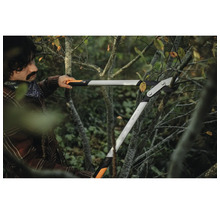 Eine Person benutzt eine Getriebeastschere, um Äste zu schneiden.