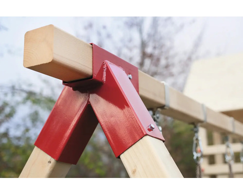Detailansicht einer Schaukelkonstruktion mit roten Metallverbindungen und Holzträgern.