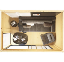 Blick von oben auf ein Wohnzimmer mit Couch, Sessel und Tischen in einem Holzhaus.