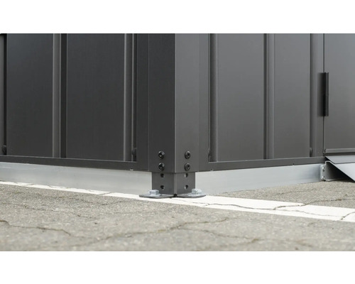 Detailansicht eines Gerätehauses mit Metallkonstruktion und Bodenbefestigung