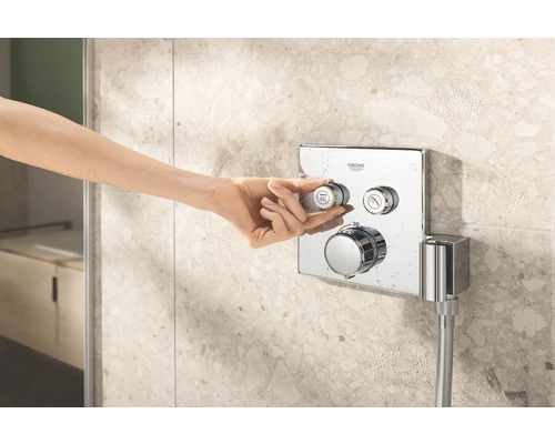 Hand betätigt Duscharmatur von Grohe im Badezimmer