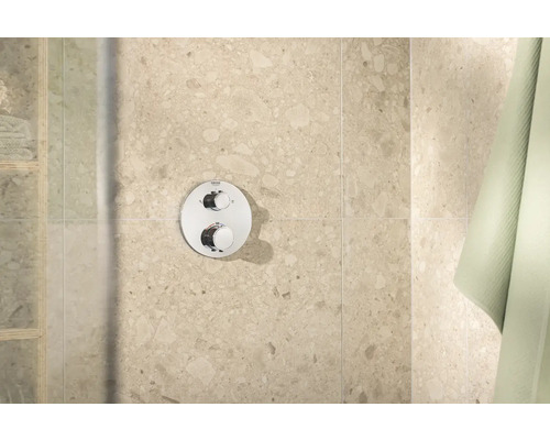 Grohe Logo. Aufputz Duscharmatur mit zwei Reglern an der Wand.
