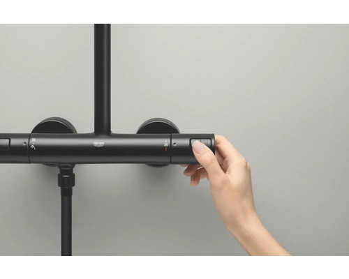 Detailaufnahme einer Hand, die eine thermostatische Duscharmatur von Grohe bedient