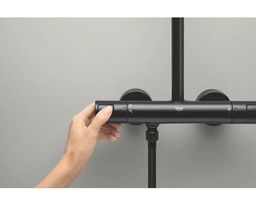 Eine Hand bedient einen Duschthermostat von Grohe
