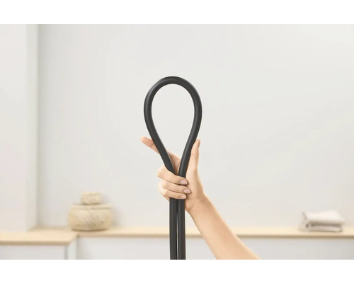 Eine Hand hält einen flexiblen, schwarzen Schlauch