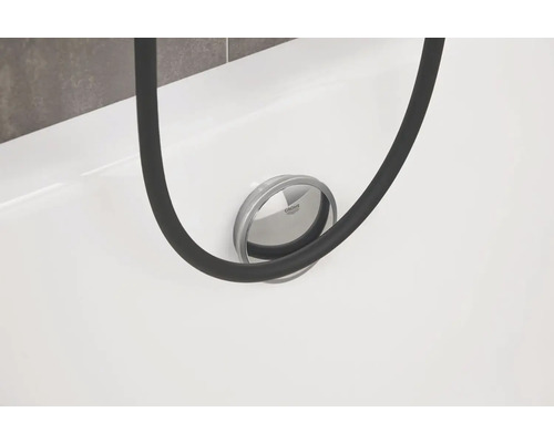 Detailansicht einer Badewanne mit Ablaufgarnitur der Marke Grohe und einem Duschschlauch