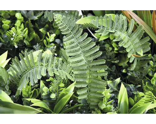 Nahaufnahme einer künstlichen Pflanzenwand mit Farnblättern und Grünpflanzen.