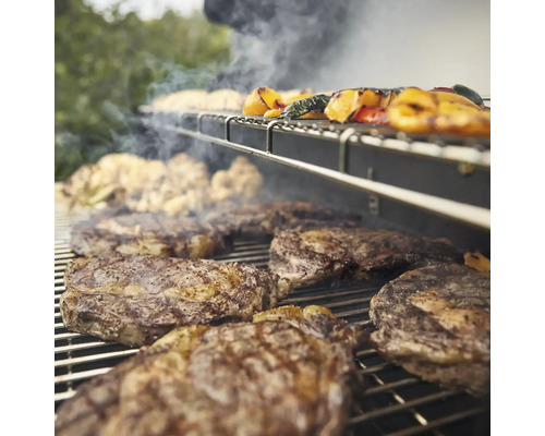 Grill mit Steaks und Gemüse auf dem Rost