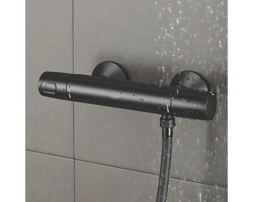Schwarzer Grohe Duschthermostat mit Brauseschlauch an gefliester Wand