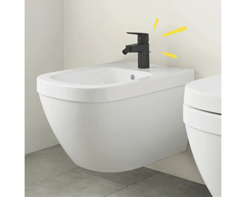 Weißes wandhängendes Bidet mit schwarzem Wasserhahn