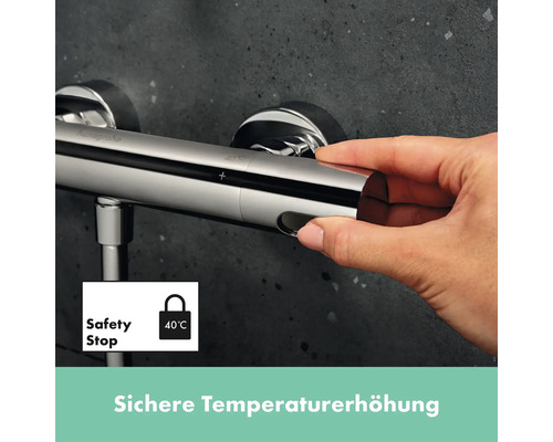 Nahaufnahme einer Hand, die einen verchromten Thermostat mit Sicherheitssperre bedient