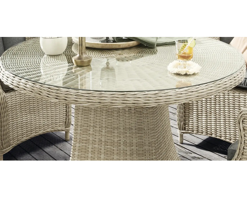 Detailansicht eines runden Gartentisches mit Glasplatte und Rattanstruktur
