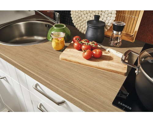 Küchenszene mit Spüle, Armatur, Arbeitsplatte, Schneidebrett und Zutaten