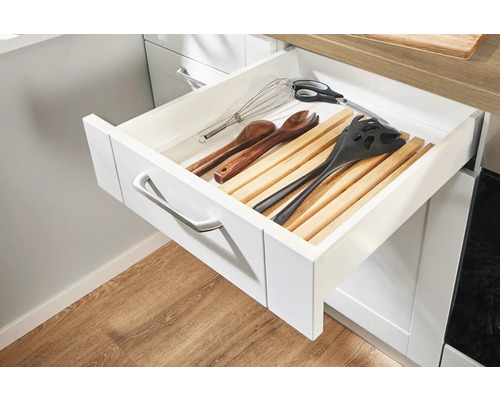 Offene Küchenschublade mit Holzeinteilung und verschiedenen Küchenutensilien.