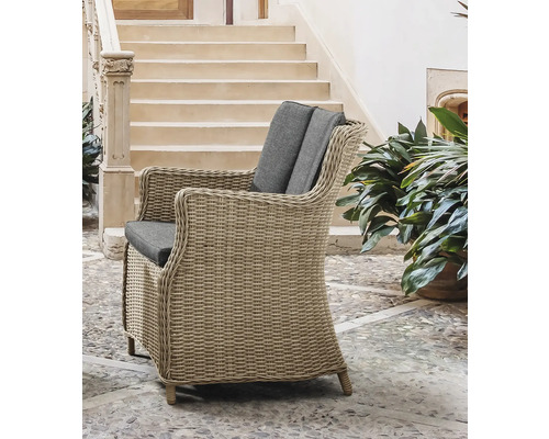 Geflochtener Sessel mit grauen Kissen im Außenbereich