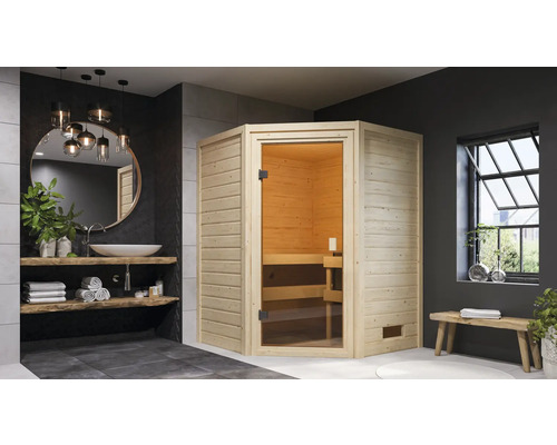 Helle Holzsauna mit Glastür in modernem Badezimmer mit Waschbecken, Spiegel und Bank.