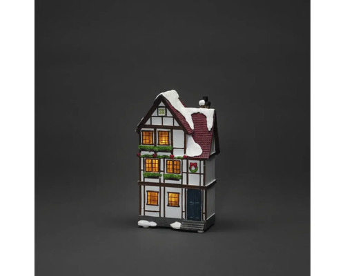 Dekoratives, beleuchtetes Fachwerkhaus mit Schnee und Weihnachtsschmuck