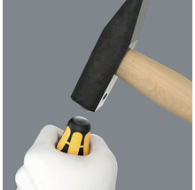 Hammer schlägt auf einen Schraubendreher-Griff in einer Hand