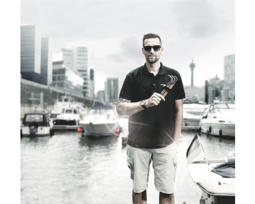 Mann mit Inbusschlüsselsatz vor einem Hafen