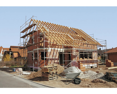 Neubau eines Hauses mit Gerüst und Baumaterialien