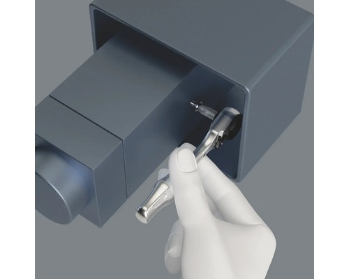 Eine Hand benutzt eine Knarre, um eine Schraube festzuziehen.