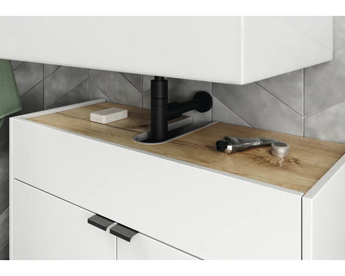 Detailaufnahme eines Waschtischunterschranks mit Armatur, Seife und Kosmetikprodukten im Badezimmer