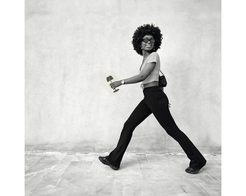 Frau geht mit einer kleinen Lampe in der Hand