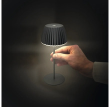 Schwarze LED-Tischleuchte mit Hand im Bild