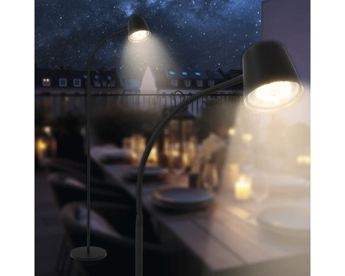 Zwei Stehleuchten beleuchten einen Tisch im Freien unter dem Sternenhimmel.